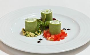Parsley crêpe rolls filled with crème fraiche served on a ragout of three kinds of vegetables