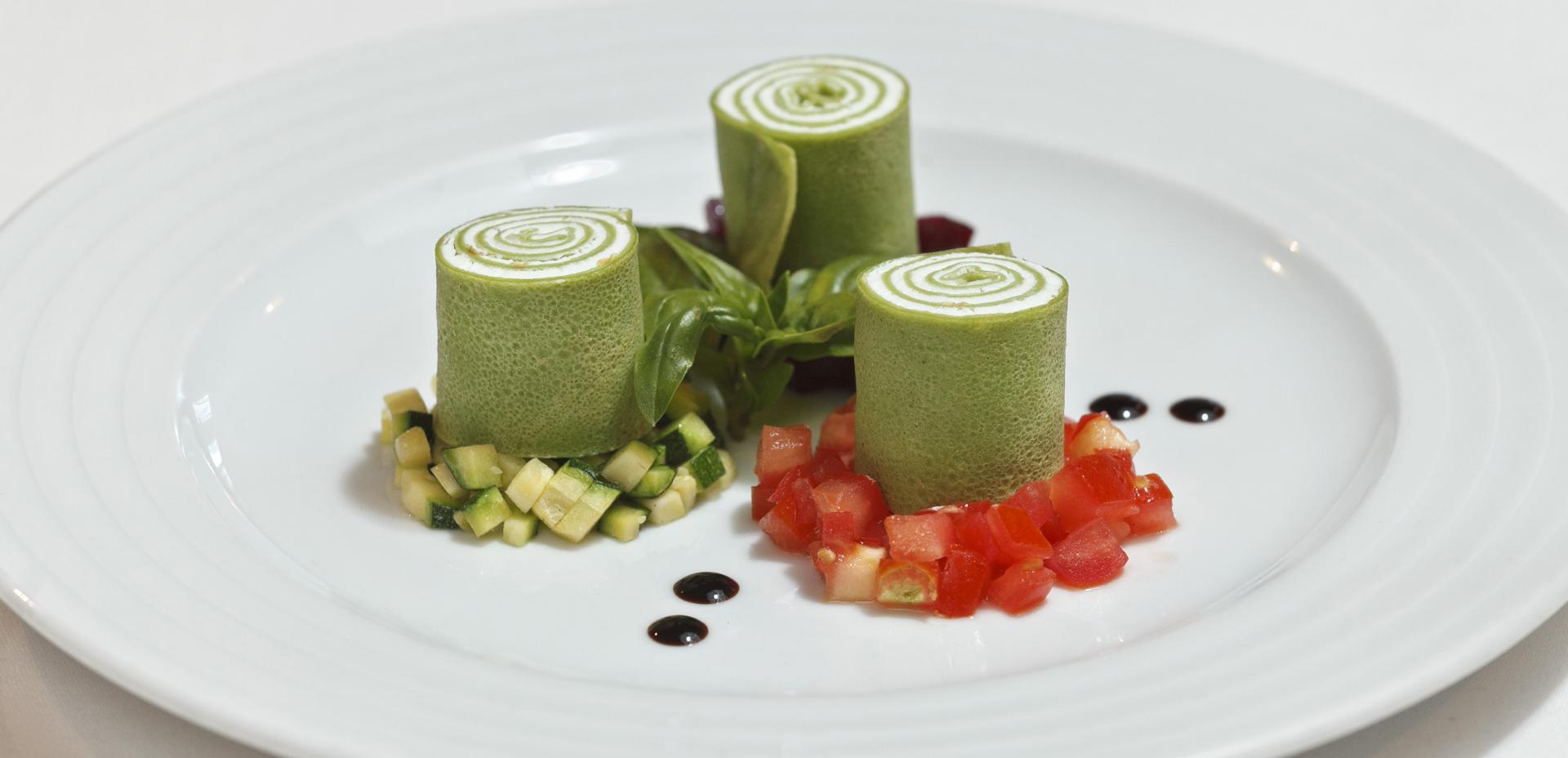Parsley crêpe rolls filled with crème fraiche served on a ragout of three kinds of vegetables